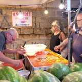Quando arriviamo troviamo l�uomo intento a tagliare fette di melone rosso per i numerosi clienti in fila, proprio accanto all�insegna che recita: �Angurie fresche da Donato�